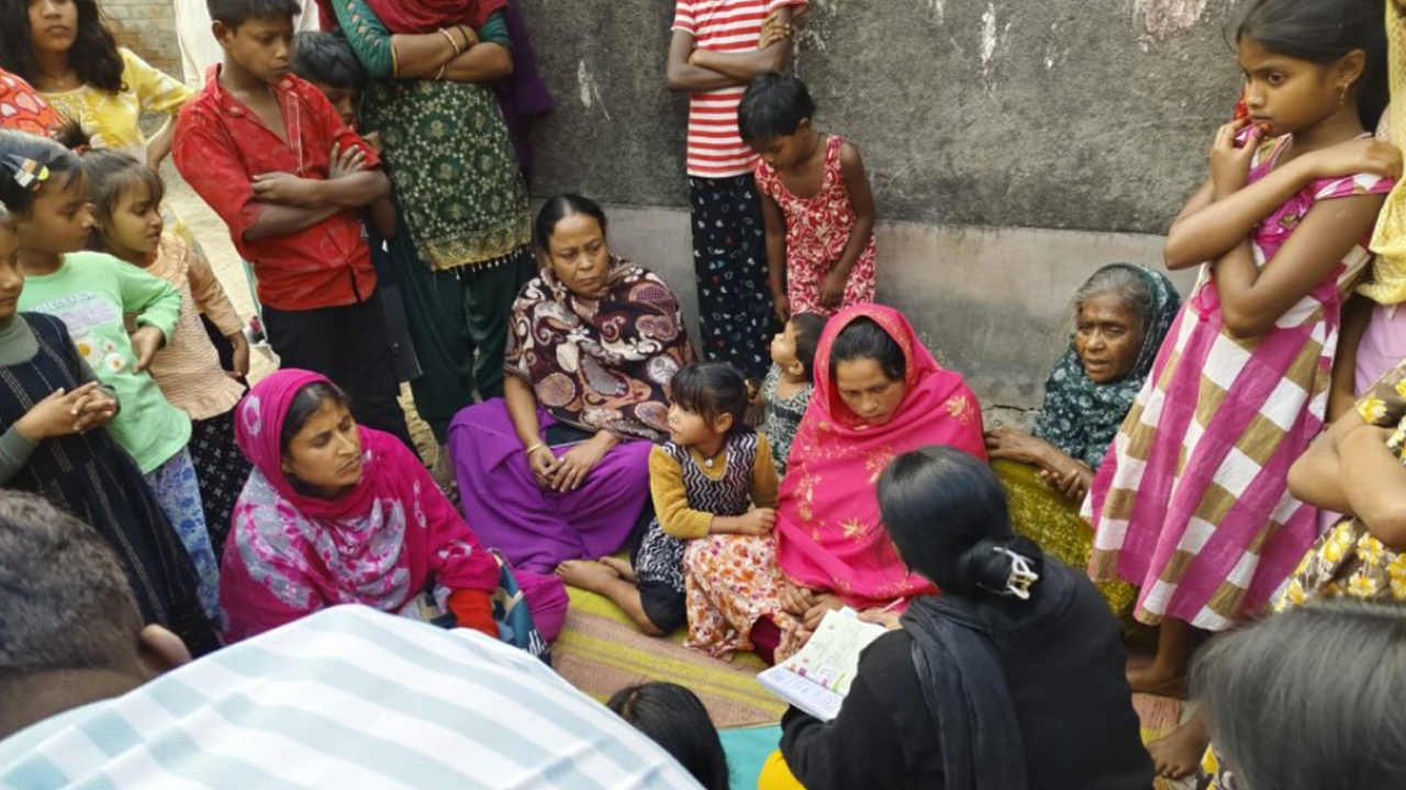 নিজের গ্রামে ফিরে এসে স্থানীয় স্বাস্থ্যকর্মীদের সঙ্গে কথা বলছেন সোনালি খাতুন (গোলাপি শাল পরা)। ছবি: মফিজুল শেখ। ইনস্ক্রিপ্ট