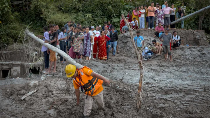 কাদা ও ধ্বংসস্তূপের মধ্যে উদ্ধার অভিযান চালানো হচ্ছে। ছবি: গেটি ইমেজেস