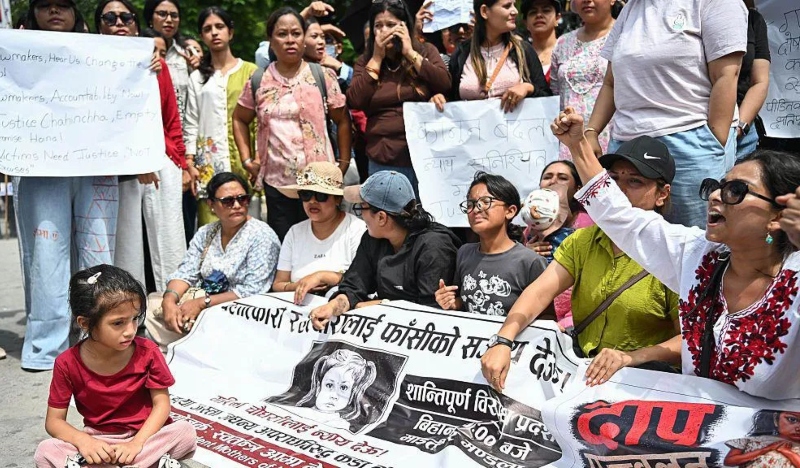 ধর্ষণের পরে হত্যার শিকার শিশুর ছবি সংবলিত ব্যানার হাতে বিক্ষোভকারীরা। ছবি: এক্স থেকে নেওয়া