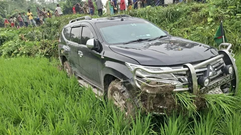 বগুড়ার শিবগঞ্জে জনপ্রশাসন প্রতিমন্ত্রীকে বহন করা গাড়ি নিয়ন্ত্রণ হারিয়ে রাস্তার পাশের জমিতে পড়ে যায়। ছবি: সংগৃহীত