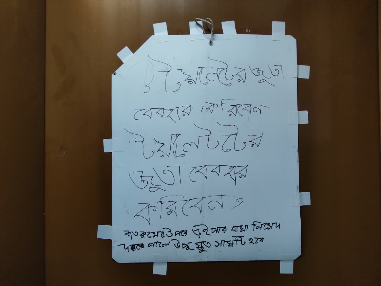 টয়লেটটির দরজায় লেখা রয়েছে ‘টয়লেটের জুতা ব্যবহার করিবেন’।