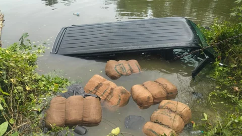 পুলিশের ধাওয়া খেয়ে পুকুরে পড়া গাঁজাভর্তি মাইক্রোবাস। সংগৃহীত ছবি